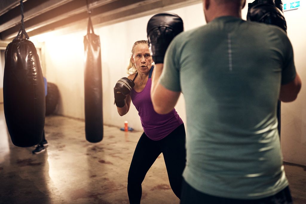 Et medlem træner slag med en instruktør i Heat Boxing Gym